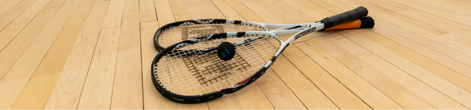 Squash rackets and ball on the floor of the squash court at One Leisure Huntingdon