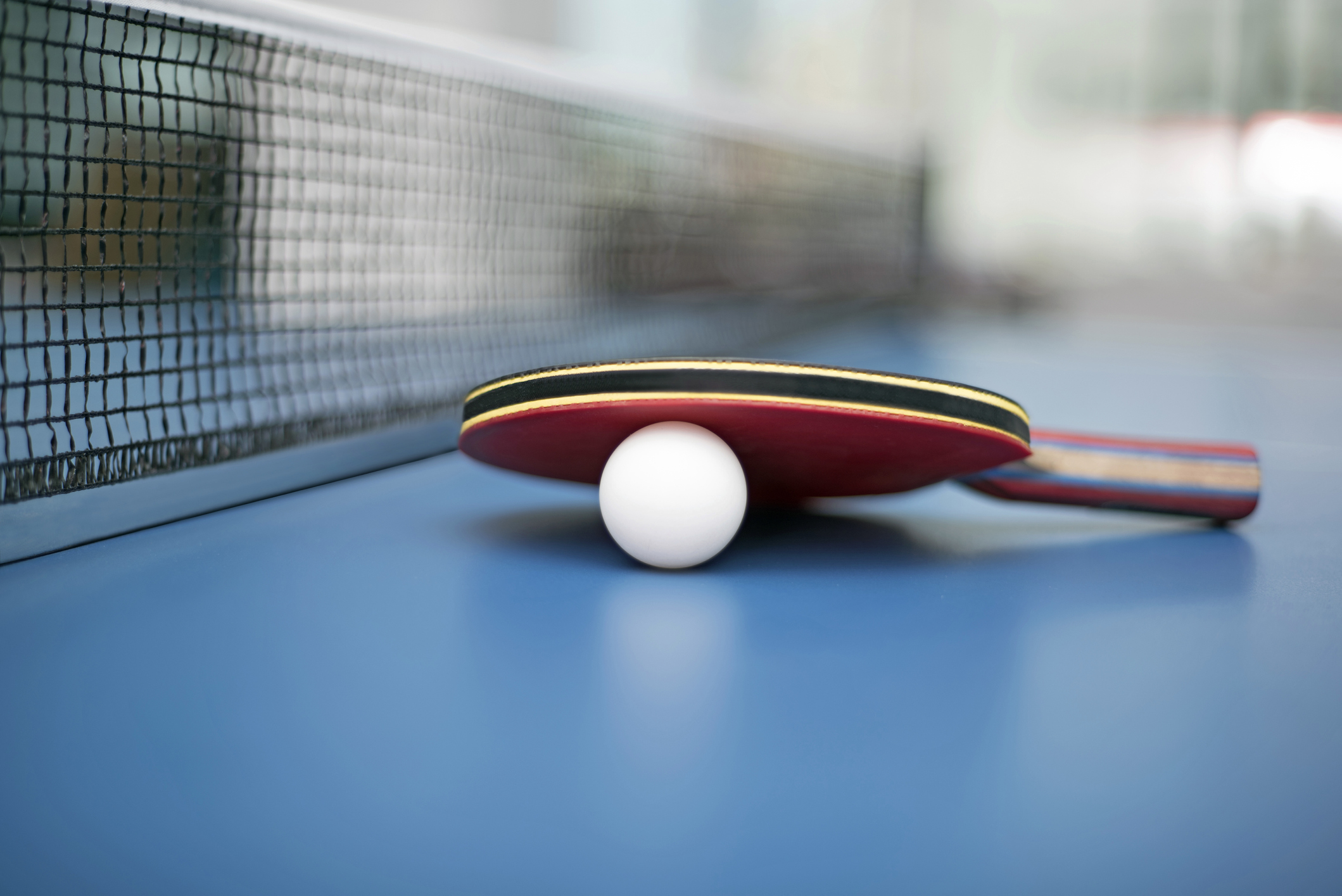 Table tennis bat and ball on a table tennis table